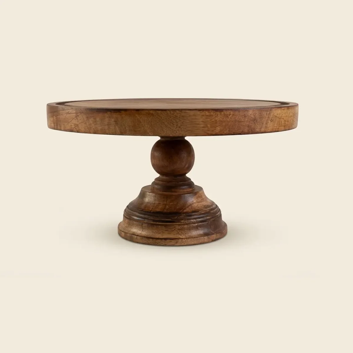 Round mango wood cake stand in walnut finish with a ball-shaped stem and a wide pedestal base, on a white background